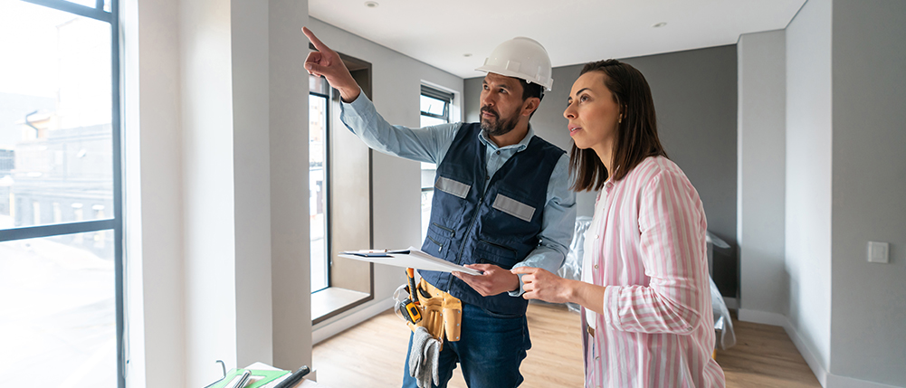 Builder explaining construction project to woman homeowner