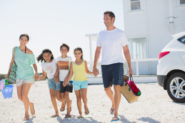 Young family enjoying their day on the beach next to their vacation home.