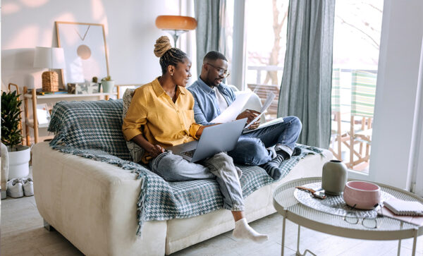 Couple looking over financial documents together on the couch