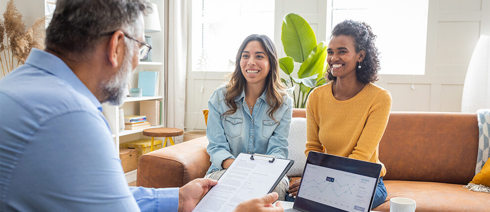 Couple happily discussing details with loan officer