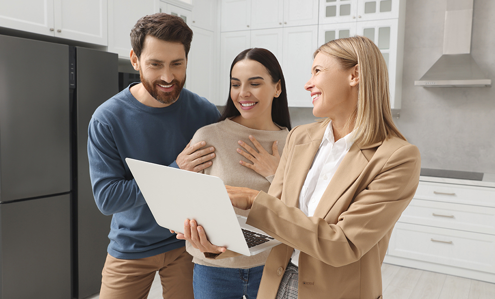 Couple smiling while reviewing documents with professional