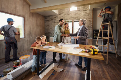 Couple discussing with builder in the middle of home building