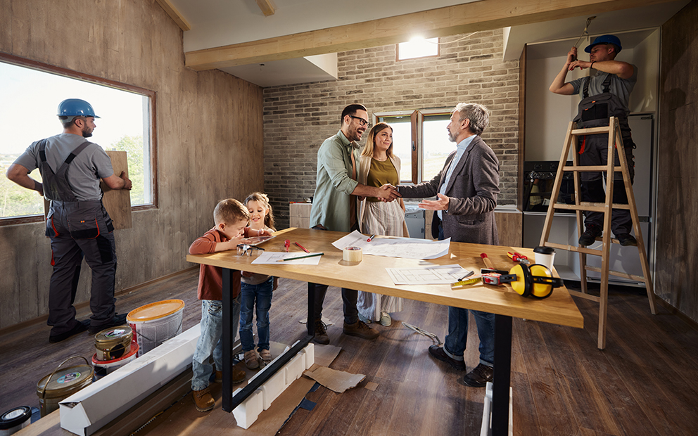 Couple discussing with builder in the middle of home building