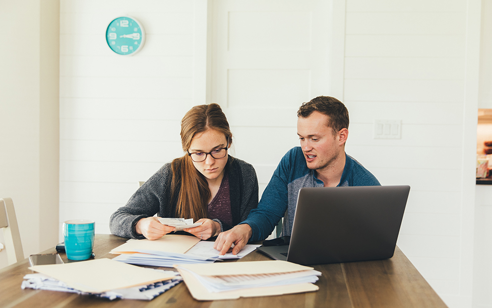 Couple sitting at dining room table while reviewing documents