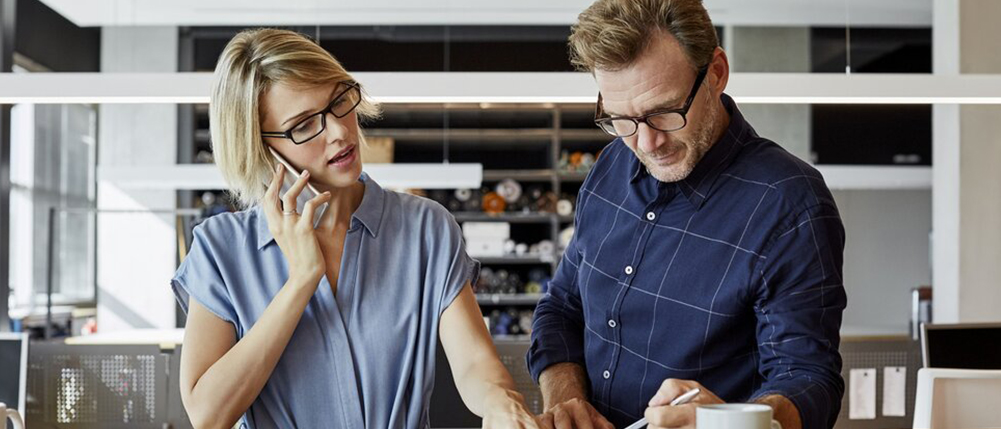 Man and woman couple discussing and reviewing finances in their home