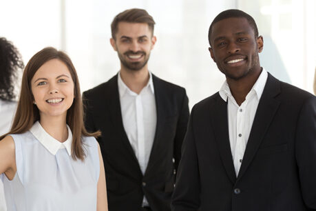 Group of men and woman dressed in business attire while smiling