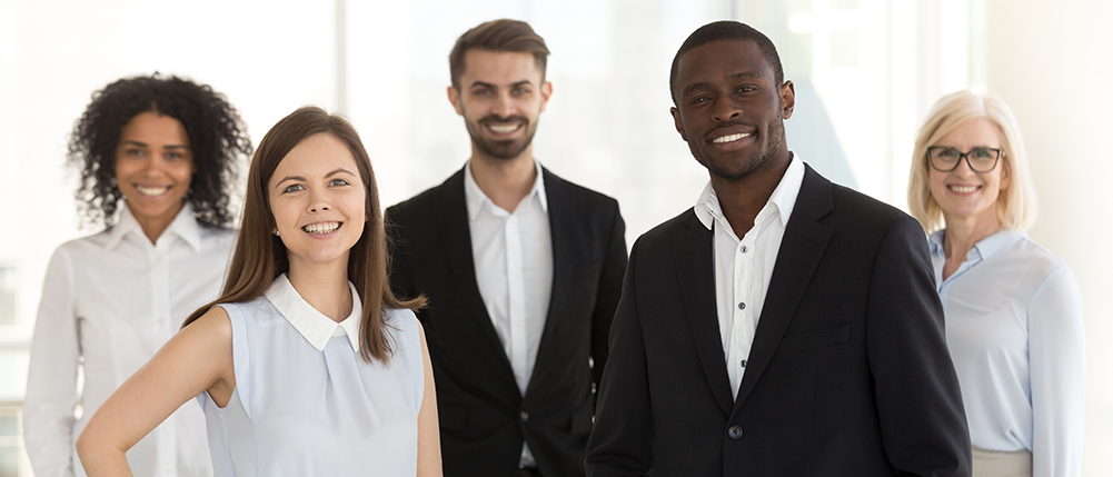 Group of men and woman dressed in business attire while smiling