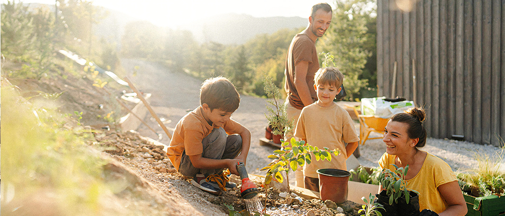 Man and woman couple gardening in yard with their two kids