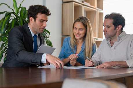 Man and woman couple going over documents with advisor while sitting at a table