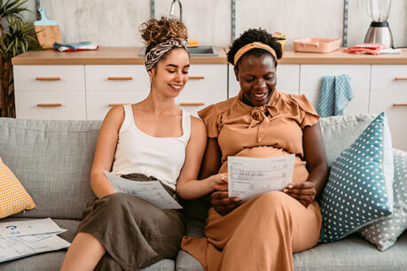 Couple happily reviewing and discussing documents together while sitting on their couch