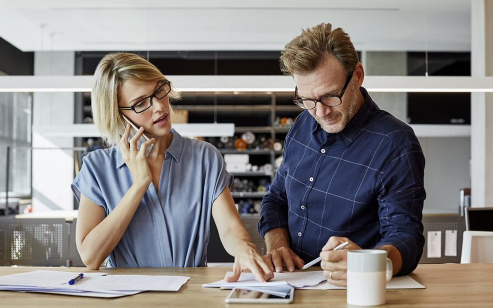 Couple looking concerned while reviewing and discussing financial documents