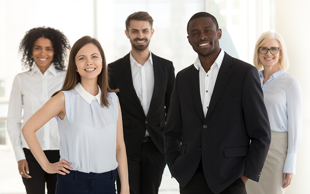 Group of men and woman dressed in business attire while smiling