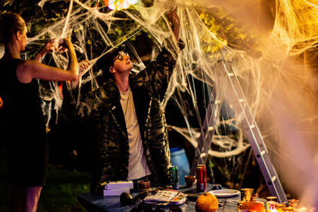 Couple setting up outside of home with Halloween decorations