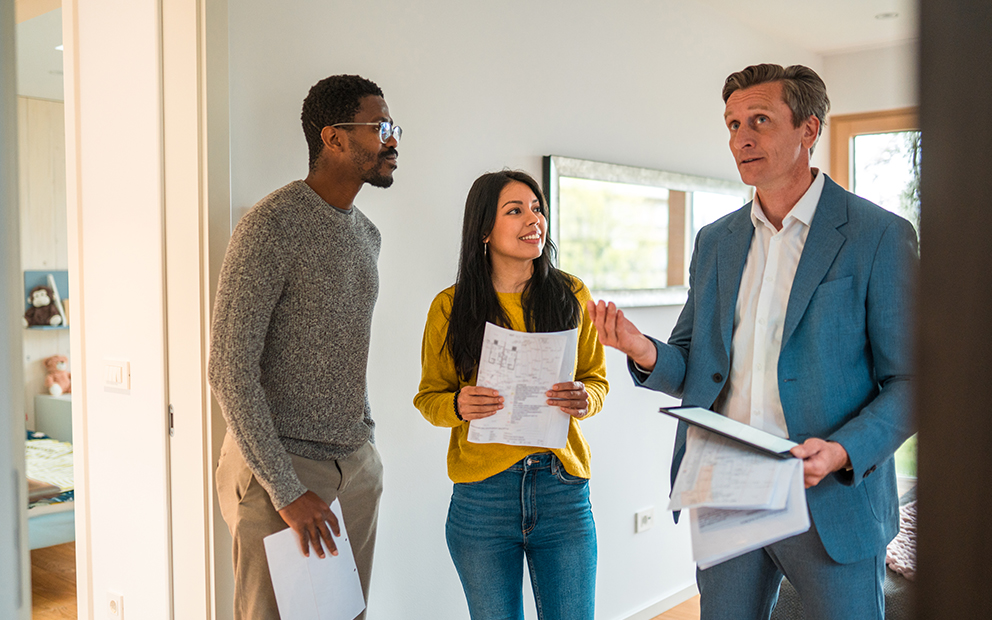 Couple discussing with realtor about house they are touring