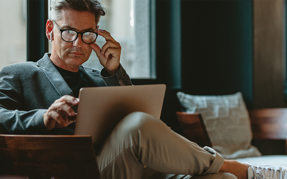 Man examining notes on laptop