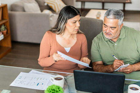 Couple sitting at table together while reviewing documents