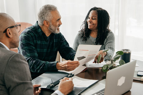 Couple smiling while discussing with advisor