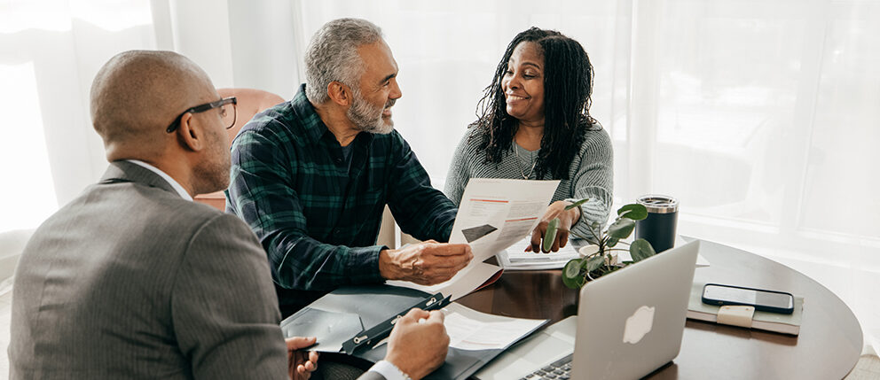 Couple smiling while discussing with advisor