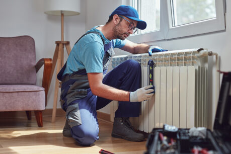 Man working on radiator inside home