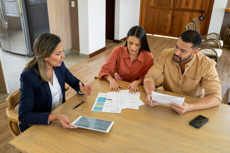 Man and woman couple sitting at table while they discuss with an advisor