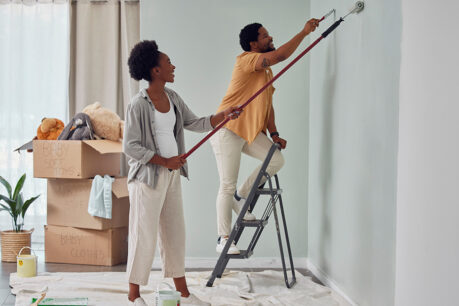 Man and woman couple painting inside of home together