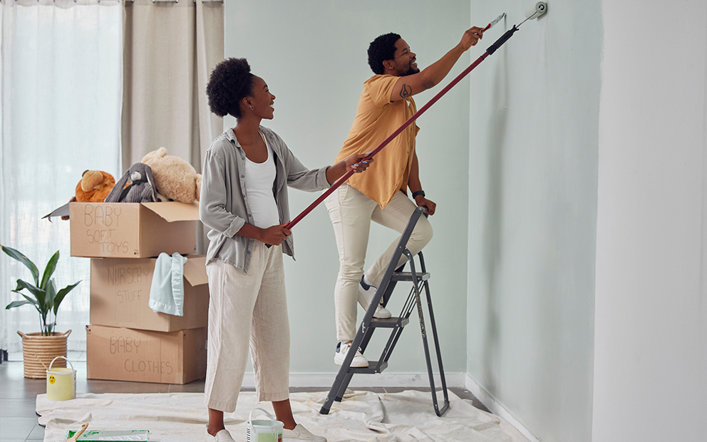 Man and woman couple painting inside of home together