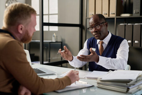 Financial advisor discussing with man as they sit across from each other at a desk