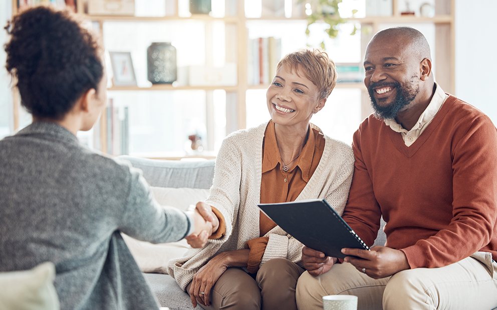 Couple sitting with and discussing with buyer consultant