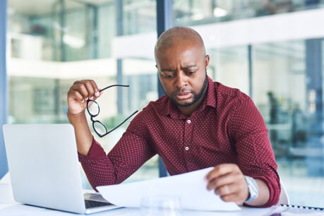 Man sitting at table while reviewing finance documents