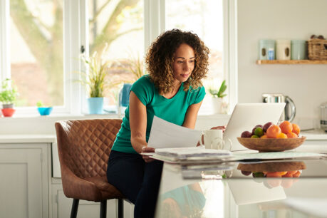 Woman sitting at kitchen table while reviwing documents