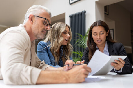 Couple speaking with advisor over finance documents