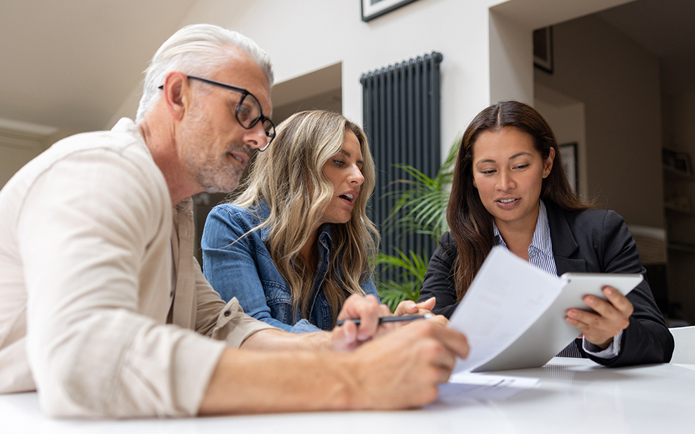 Couple speaking with advisor over finance documents