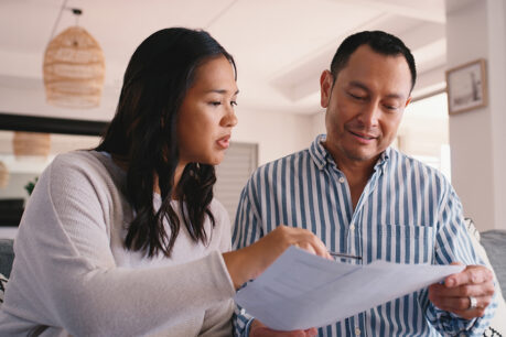 Couple sitting together while looking over documents